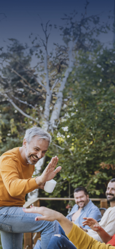 Image d’un homme souriant assis sur une rambarde et faisant un signe de main aux personnes en face de lui